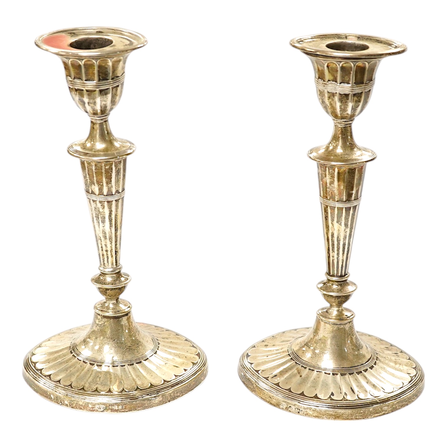 A matched pair of Edwardian silver oval candlesticks, Hawksworth, Eyre & Co and Goldsmiths & Silversmiths Co Ltd, height 21.9cm, weighted. Condition - fair